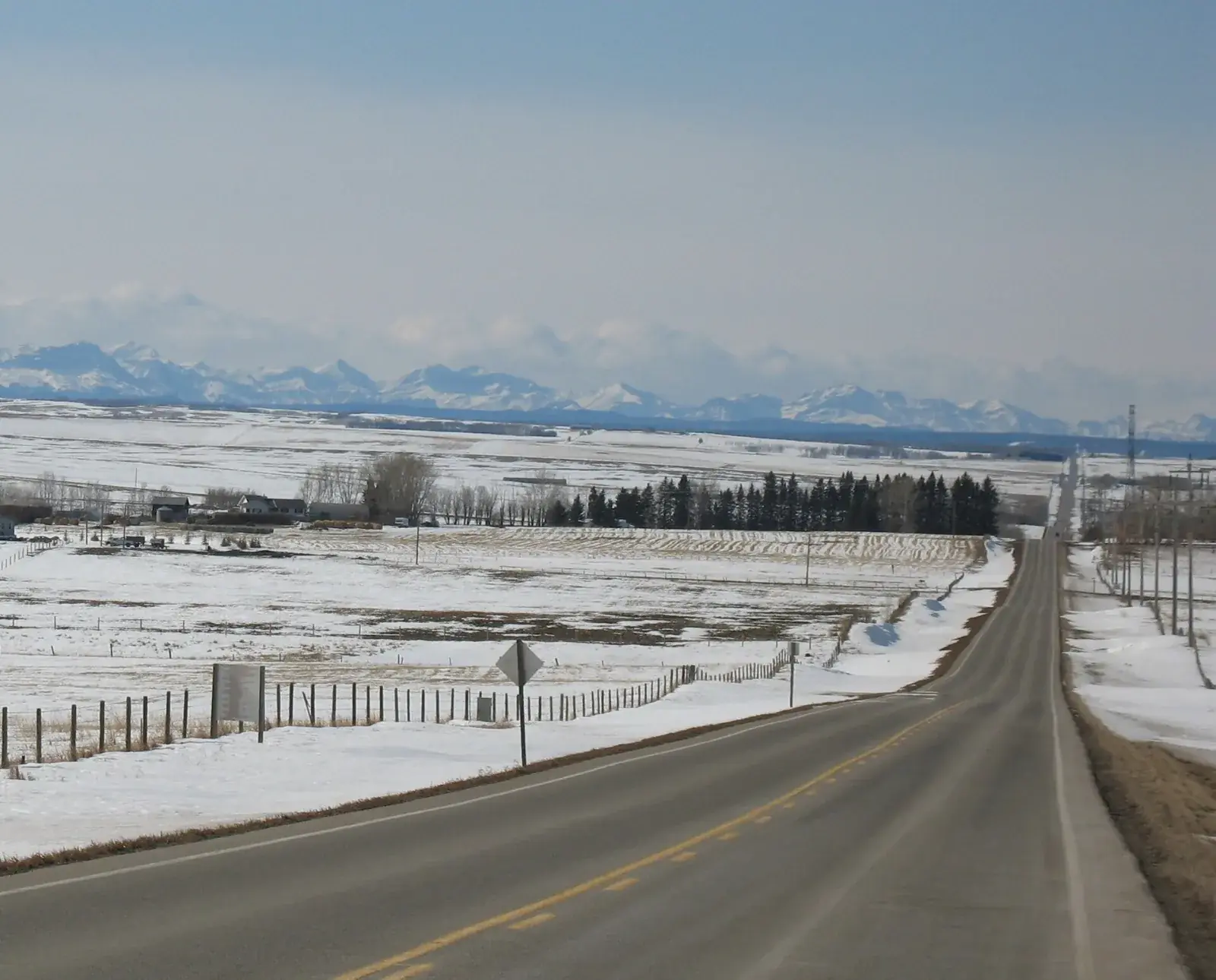 Highway 580 near Cremona in winter with the Rocky Mountains on the horizon