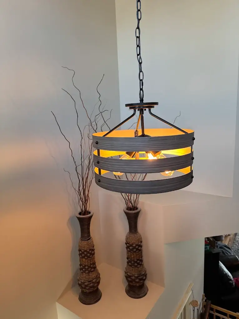 Drum pendant light with exposed filament bulbs on a landing